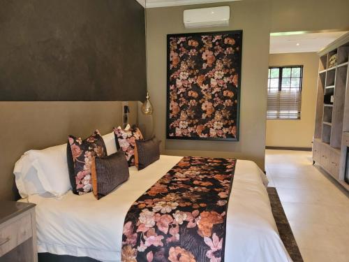 a bedroom with a bed with a floral tapestry on the wall at Kievits Kroon Gauteng Wine Estate in Pretoria