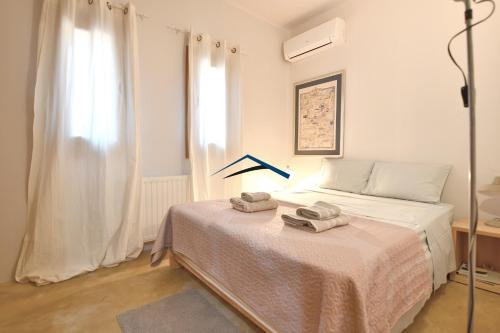 a bedroom with a bed with two towels on it at The Charming Waterfront Retreat, with a swimming pool & direct access to the sea, ideal for large families, or a group of friends in Otzias