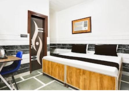 a room with two beds and a table and a desk at Happy star hotel in New Delhi
