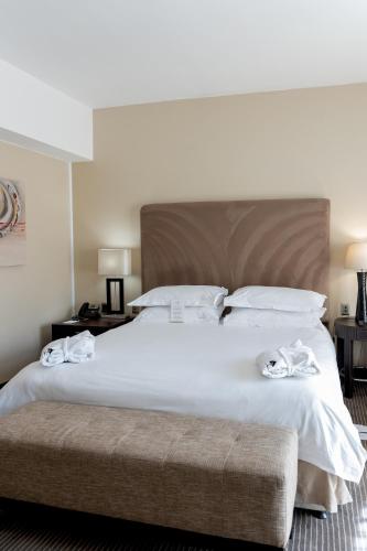 a large white bed with two towels on it at Kievits Kroon Gauteng Wine Estate in Pretoria