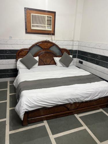 a bedroom with a wooden bed with pillows on it at Happy star hotel in New Delhi