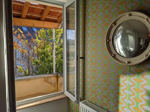 un miroir sur un mur à côté d'une fenêtre dans l'établissement Maison des Vignes, à Saint-Maurice-des-Champs