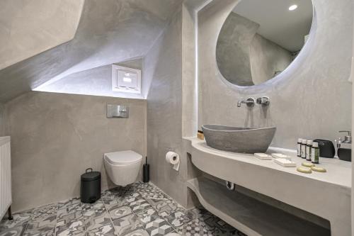 a bathroom with a sink and a toilet and a mirror at Villa Bazeos in Agkidia