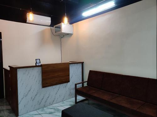a waiting room with a couch and a light at Moonic Days Infopark Kakkanad in Kakkanad