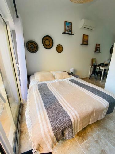 une chambre avec un lit avec une couverture dessus dans l'établissement Le studio de Marie, à Noves