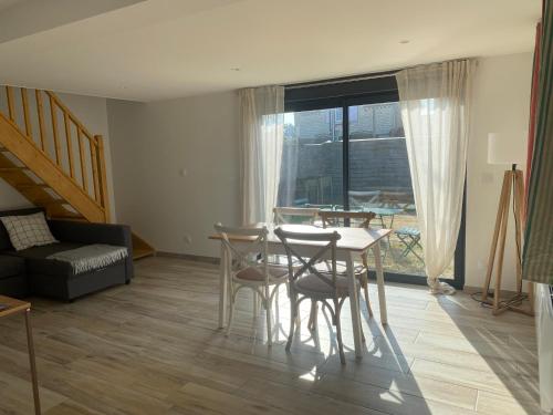 un salon avec une table, des chaises et un canapé dans l'établissement Petite maison proche plage, à Ouistreham
