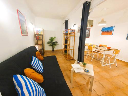 un salon avec un canapé noir et une table dans l'établissement Vieux Nice Place Garibaldi - cozy flat, à Nice