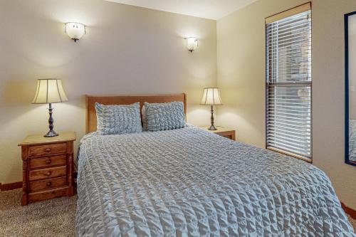 a bedroom with a bed and two lamps and a window at Tranquil Pines at Seventh Mountain in Bend