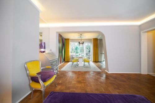 een woonkamer met gele stoelen en een tafel bij Favorite Stays - Suite and More - Deluxe in Neuss