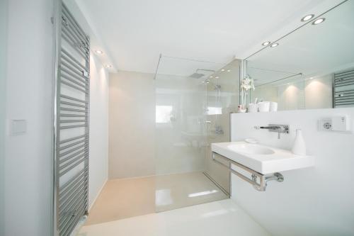 een witte badkamer met een wastafel en een spiegel bij Favorite Stays - Suite and More - Deluxe in Neuss