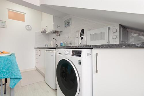 a white kitchen with a washer and dryer at Seixal Yachting Bay Original in Seixal