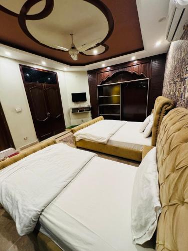 a hotel room with two beds and a kitchen at MadCrew Guest House in Islamabad