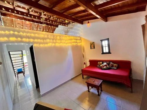 Una sala de estar con un sofá rojo y una mesa. en El silvio descanso, en Mar de Ajó