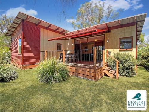 a small house with a large deck in a yard at Island Haven Villa, Resort Phillip Island in Cowes