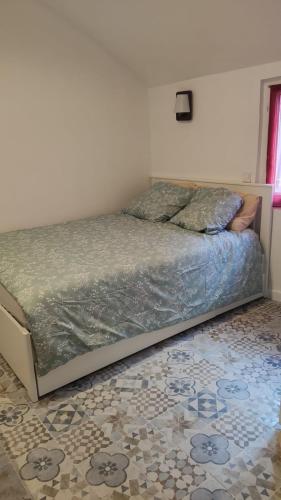 - un lit dans une chambre avec un sol dans l'établissement Promotion du Jour - Studio Le Palmier, à Deuil-la-Barre