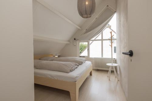 un dormitorio con una cama y una ventana en -Casa Como- nabij het meer, restaurants & keukenhof, en Noordwijkerhout