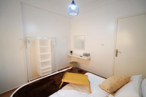 タンジェにあるCozy Stay near airportのテーブル付きのベッドが備わる客室です。