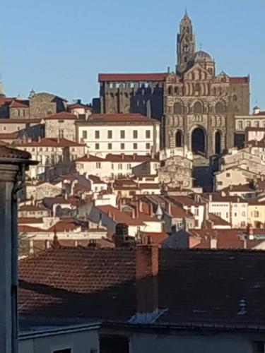 une vue d'une ville avec une cathédrale et des bâtiments dans l'établissement Très bel F2 à deux pas du centre ancien, au Puy-en-Velay