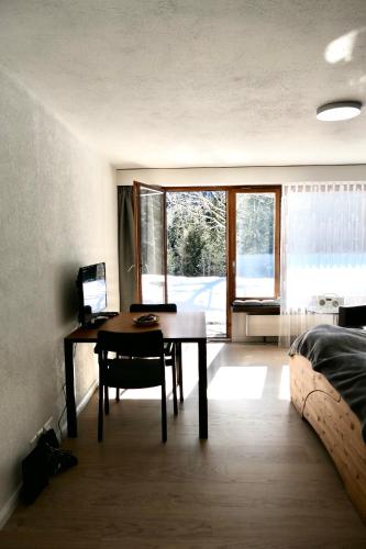 a room with a desk and a table and a bed at Marlenca 2 in Arosa