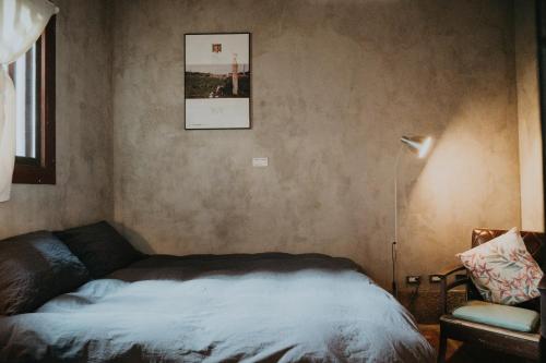 a bedroom with a bed and a picture on the wall at 島中大厝 in Jinhu