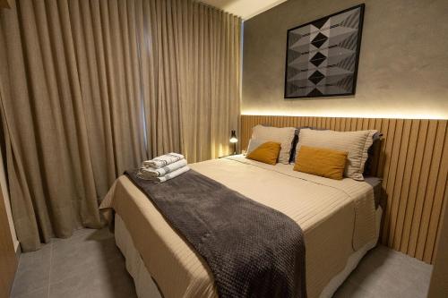 a bedroom with a large bed with orange pillows at Bee Guest - Apartamentos de Temporada Luxxor Flat in Cuiabá