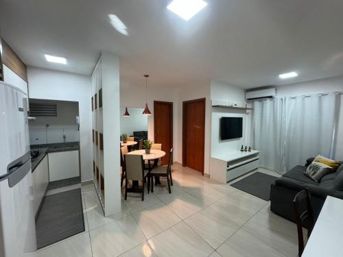 a living room and kitchen with a table and a couch at Bee Guest - Apartamentos de Temporada Luxxor Flat in Cuiabá