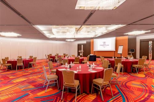 a conference room with tables and chairs and a screen at ANA Crowne Plaza Kobe by IHG in Kobe