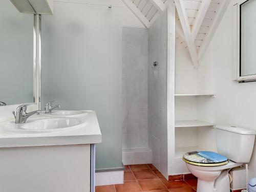 a white bathroom with a sink and a toilet at villa Caraibes proche plage in Sainte-Anne