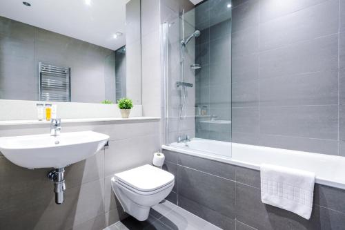 a bathroom with a sink and a toilet and a shower at Hilltop Serviced Apartments - Ancoats in Manchester