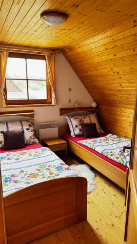 a bedroom with two beds in a cabin at Drevenička Anička - Liptovská Mara in Liptovský Trnovec