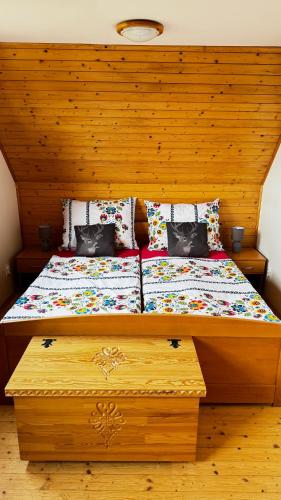 a bed with a wooden headboard and pillows at Drevenička Anička - Liptovská Mara in Liptovský Trnovec