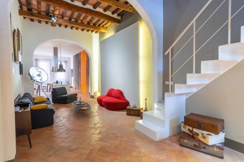 a living room with a red couch and stairs at Casatorre dei Leoni - Apartments in Siena