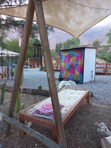 a bed in a tent with a painting on it at Casa Puente en Rivadavia in Vicuña