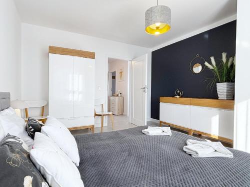 a bedroom with a bed and a black wall at Sun Towers - Apartamenty Bryza - Apartamenty z parkingiem in Świnoujście