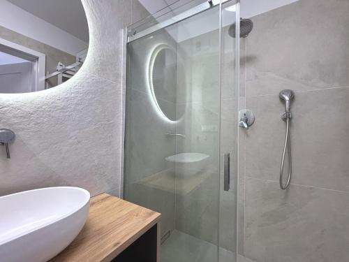 a bathroom with a glass shower and a sink at Sun Towers - Apartamenty Bryza - Apartamenty z parkingiem in Świnoujście