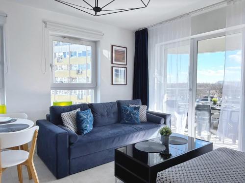 a living room with a blue couch and a table at Sun Towers - Apartamenty Bryza - Apartamenty z parkingiem in Świnoujście