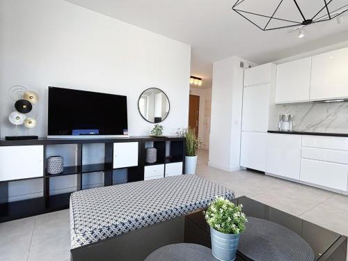 a living room with a table and a tv at Sun Towers - Apartamenty Bryza - Apartamenty z parkingiem in Świnoujście