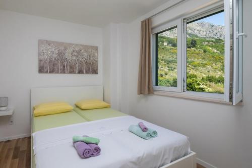 a bedroom with two beds and a window at Apartmani Noah - Mia in Celina