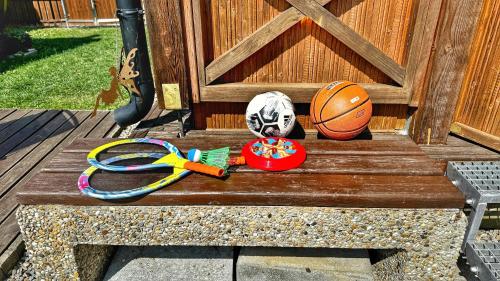 a wooden bench with a basketball and other toys on it at Drevenička Anička - Liptovská Mara in Liptovský Trnovec