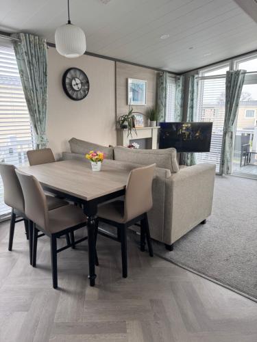 a living room with a table and a couch at 2 Bedroom Villa - Lakeside Holiday Park in Merston