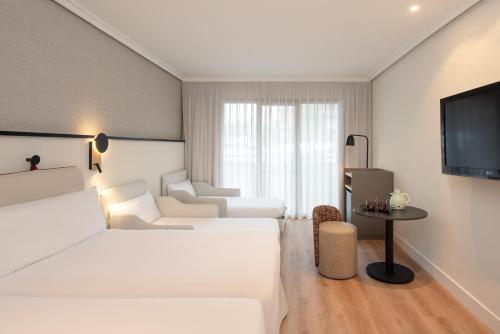 a living room with white furniture and a flat screen tv at Hotel Madrid Alameda Aeropuerto, Affiliated by Meliá in Madrid