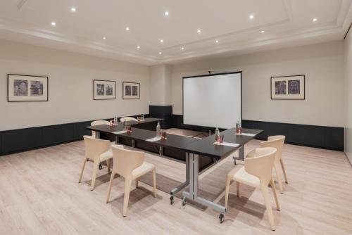 a conference room with a table and chairs and a whiteboard at Hotel Madrid Alameda Aeropuerto, Affiliated by Meliá in Madrid