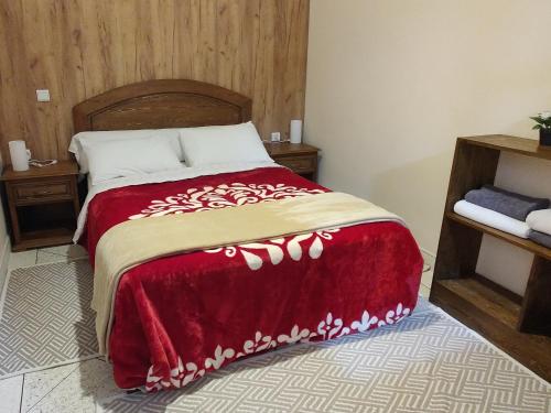 une chambre avec un lit avec une couverture rouge dans l'établissement Araucaria, à Essaouira