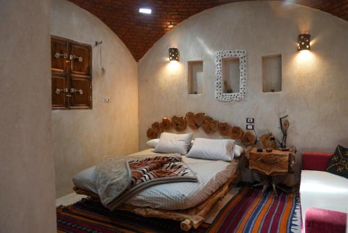 a bedroom with a bed with a wooden head board at People to People Siwa in Siwa