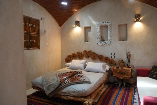 a bedroom with a large bed with a wooden headboard at People to People Siwa in Siwa