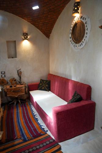 a living room with a red couch and a table at People to People Siwa in Siwa