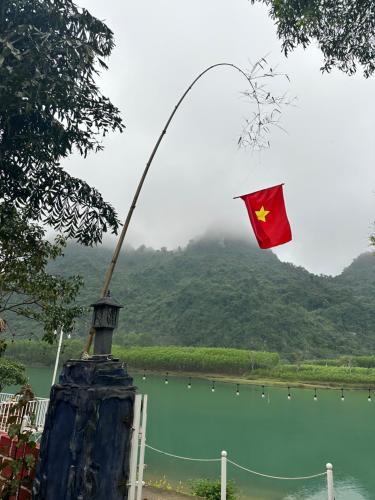 a flag flying in the air next to a body of water at Son River House in Phong Nha