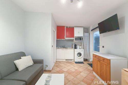 un salon avec un canapé et une cuisine dans l'établissement Flexliving - Studio - Diderot, à Paris