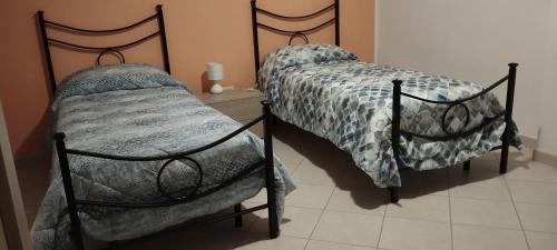 sypialnia z dwoma pojedynczymi łóżkami w pokoju w obiekcie CASAVACANZA - Marina w mieście San Salvo