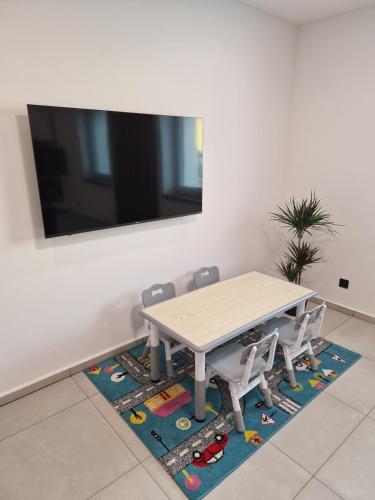 a dining room table with two chairs on a rug at RONI Apartments Krkonoše in Cerny Dul